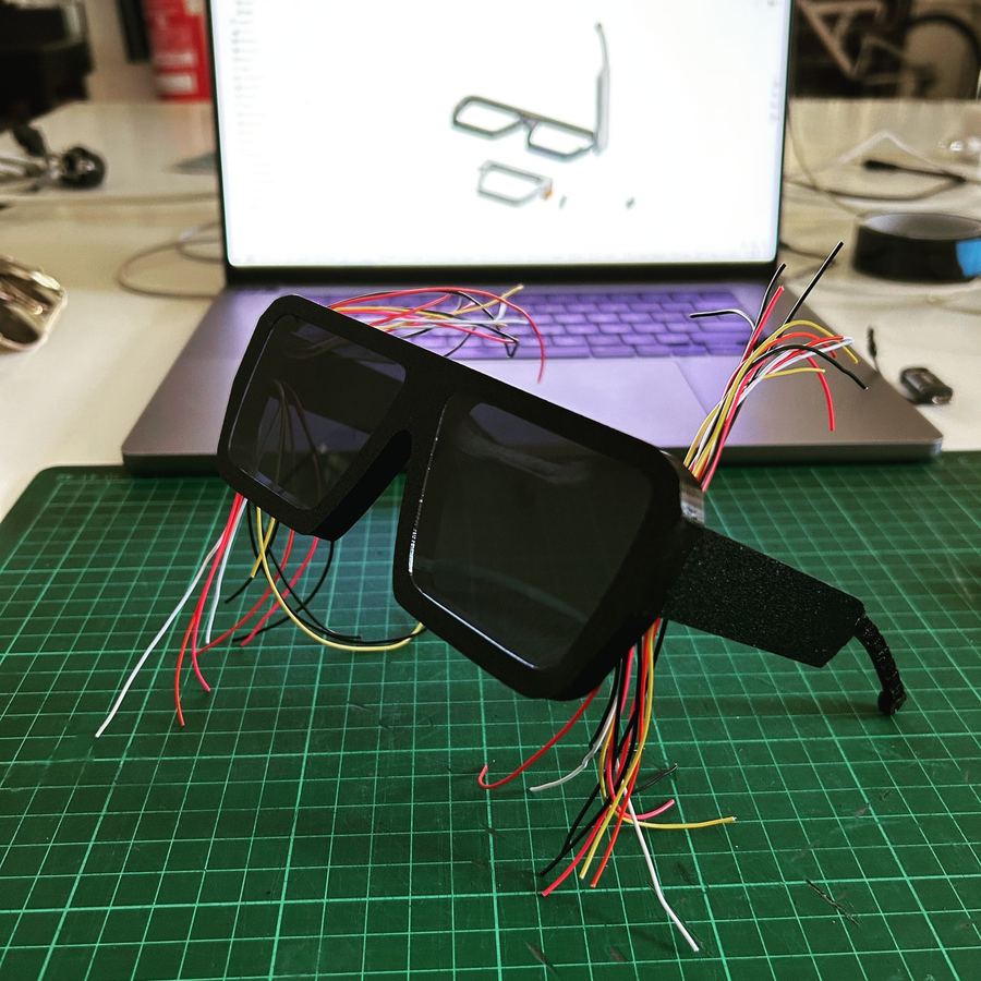 Black glasses frame with coloured wires coming out of the arm