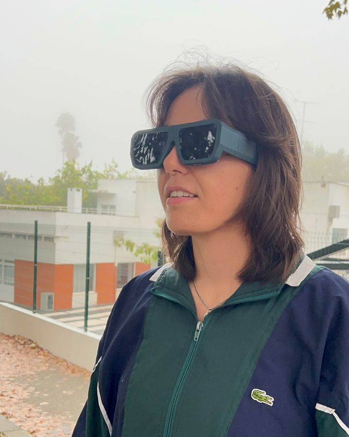 A woman in a green track jacket wearing the glasses outside