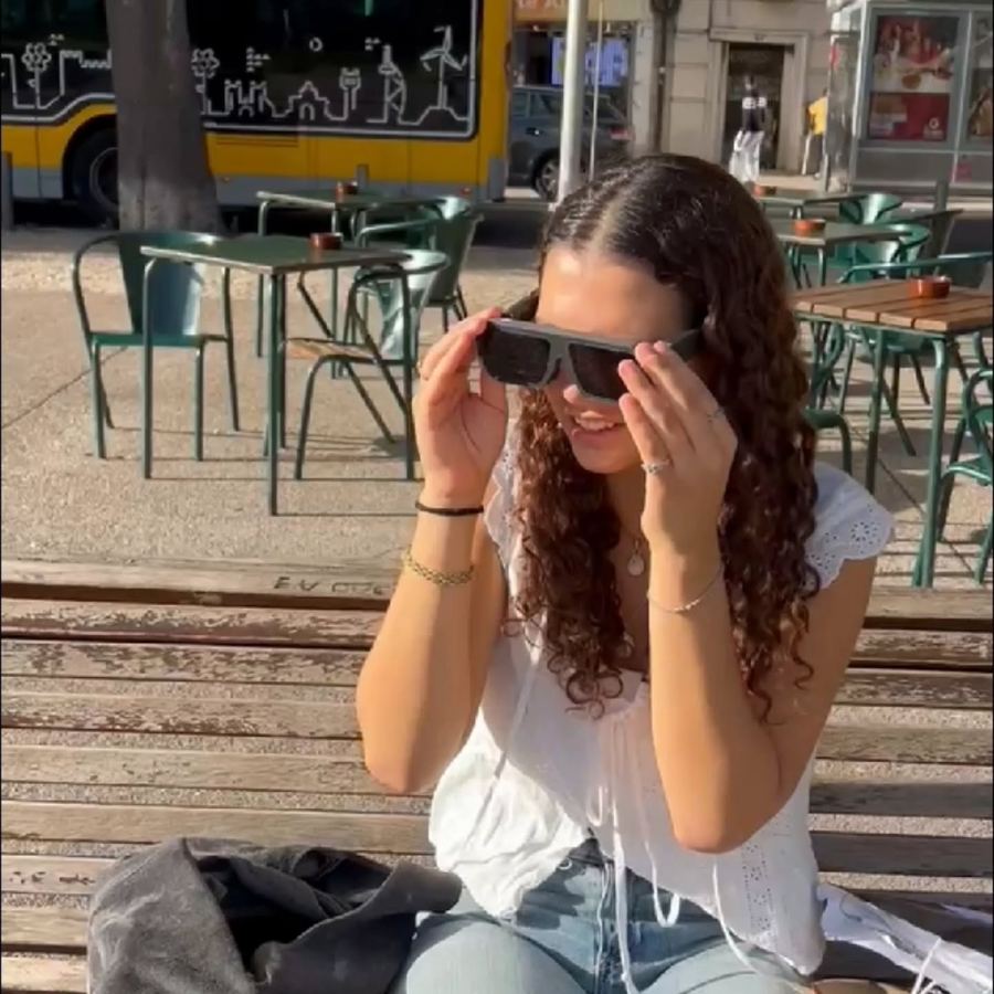 A woman adjusting the glasses at an outdoor café