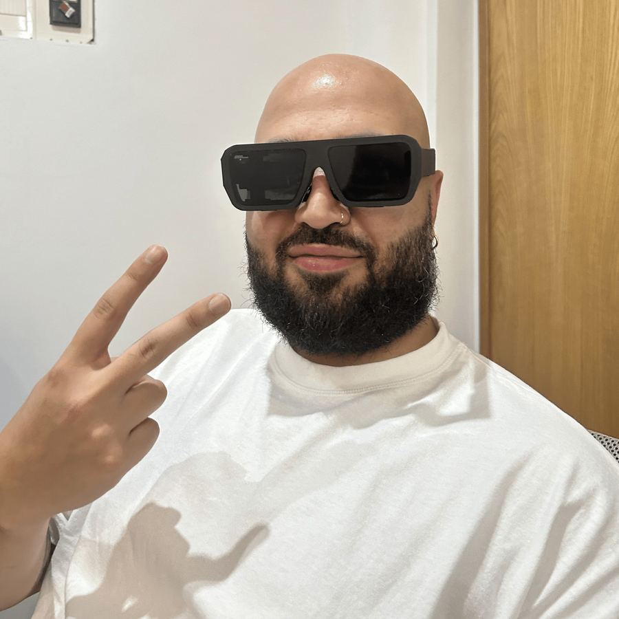 A man in a white T-shirt making a peace sign in the glasses