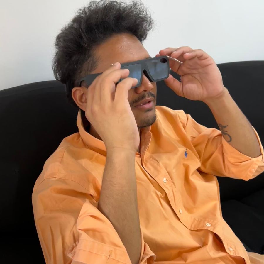 A man in an orange shirt adjusting the glasses