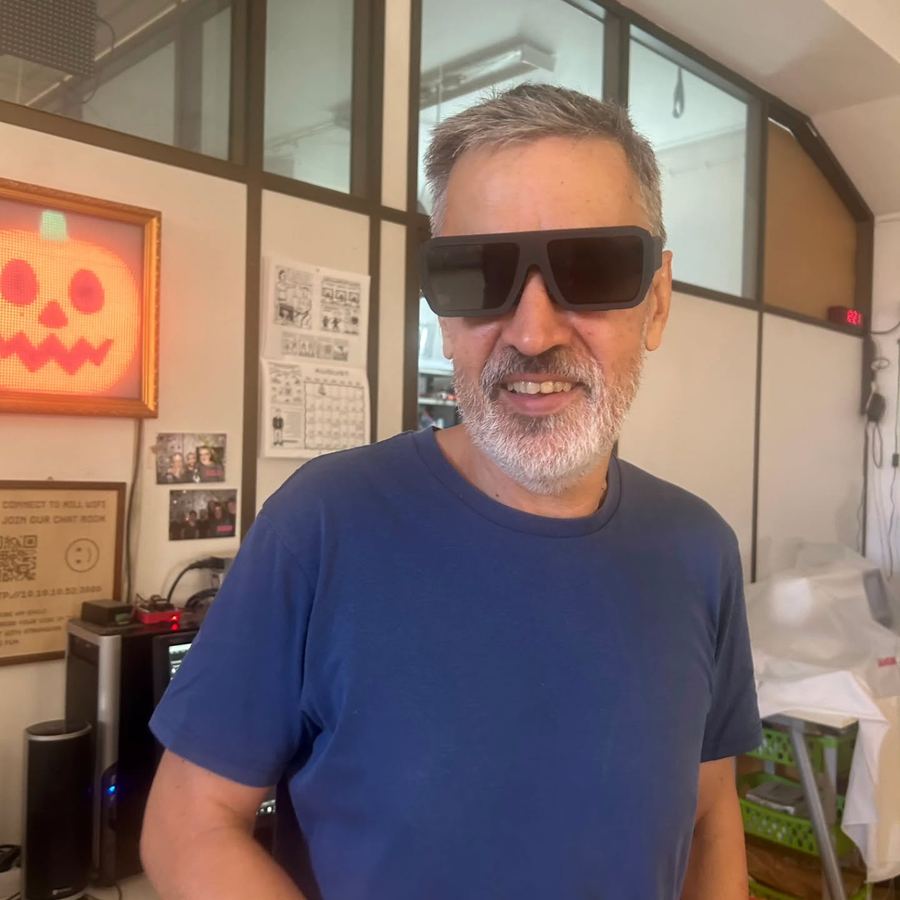 A grey-bearded man smiling in the glasses